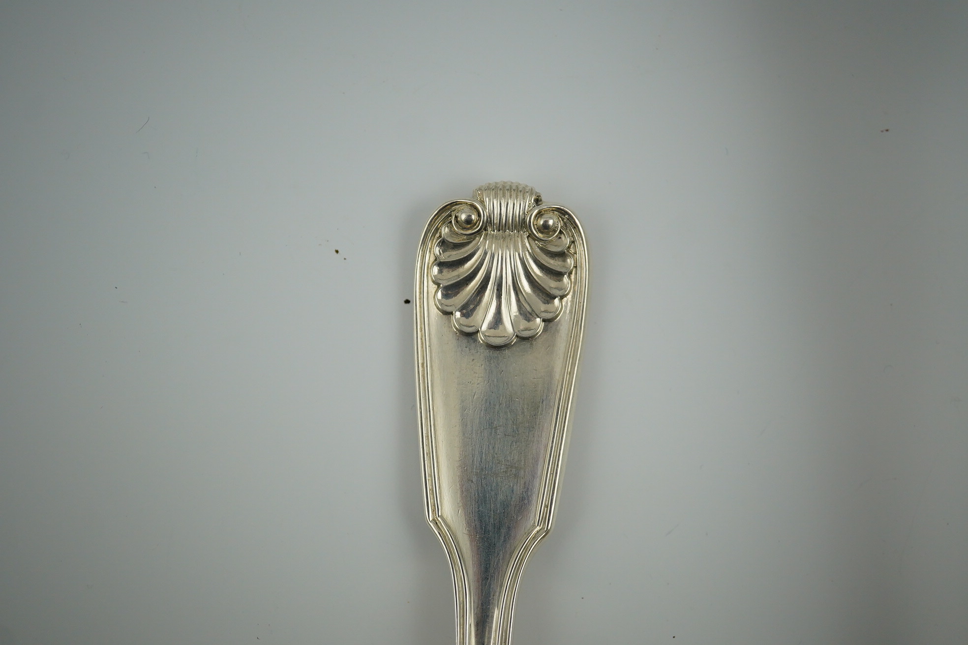 A Victorian silver fiddle, thread and shell pattern fish server and a similar shell pattern fish slice, John James Whiting, London, 1857 and William Eaton, London, 1836 respectively